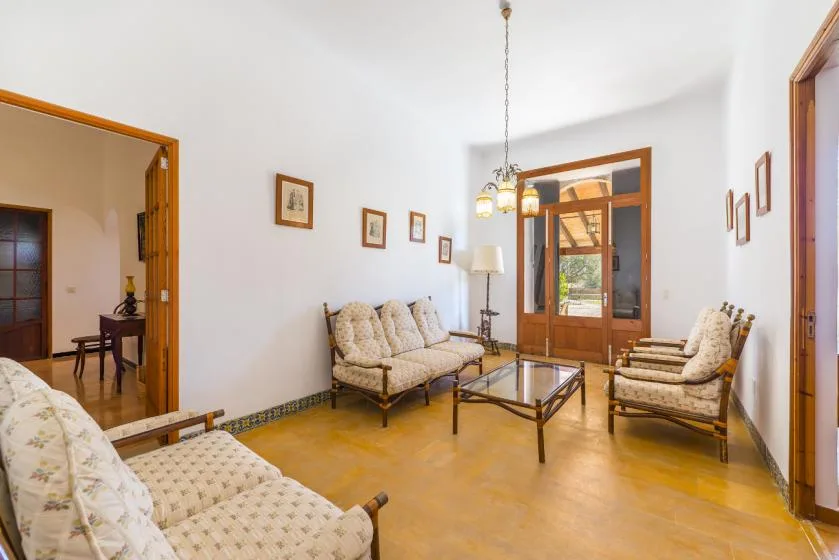 A bright living room with seating arranged around a glass coffee table.