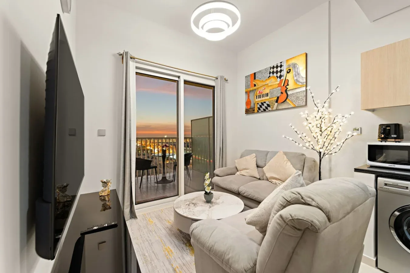 A bright living room with seating beside glass doors opening onto a balcony.