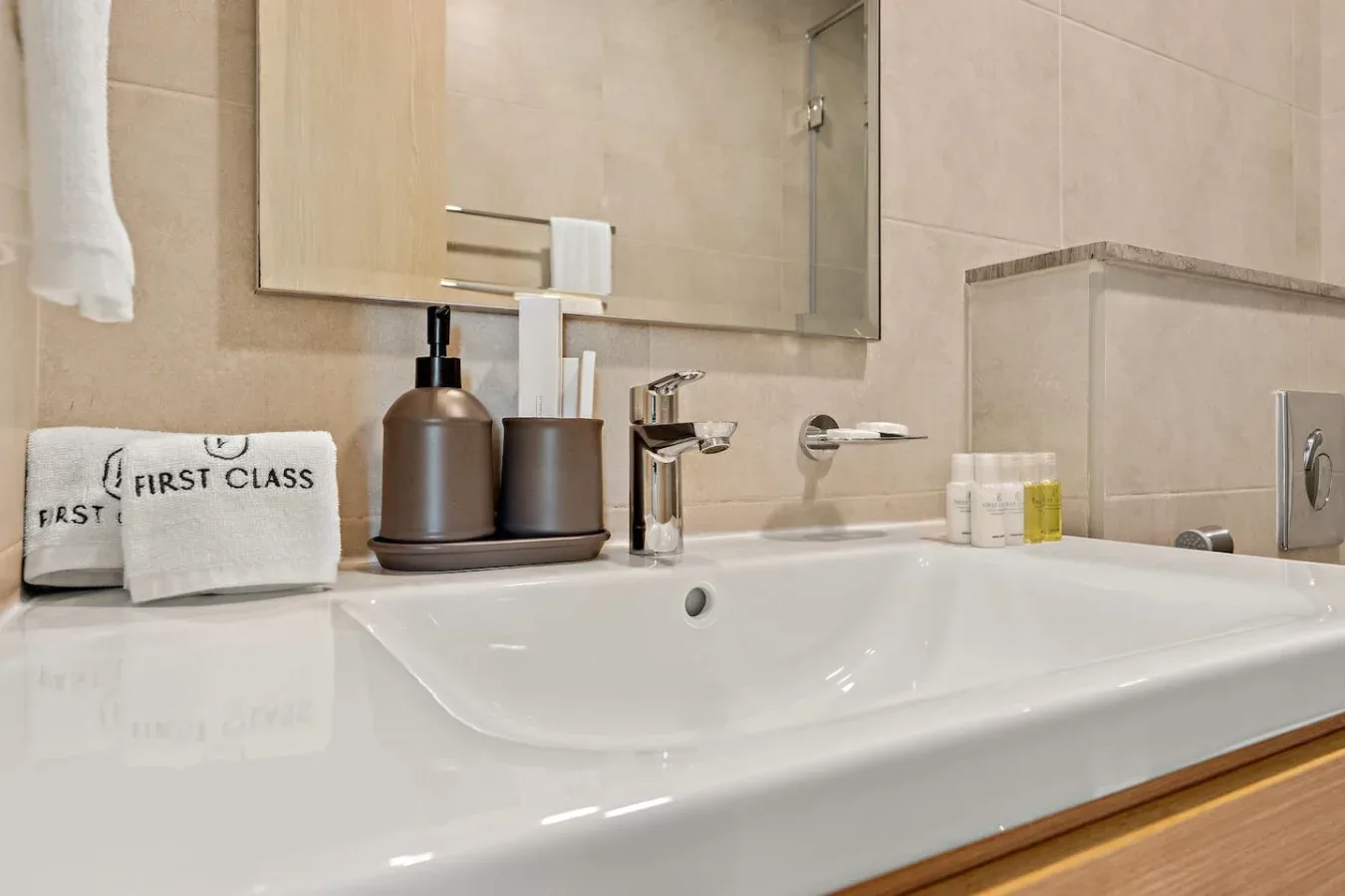 A bathroom vanity with a white sink, faucet, and toiletries beneath a mirror.