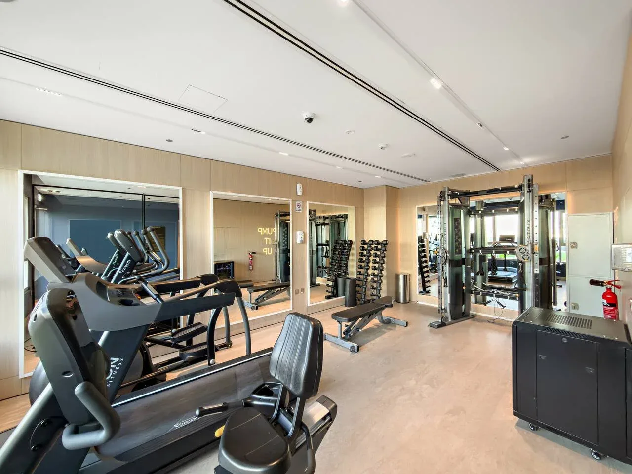 A fitness room with treadmills, weight racks, and strength-training equipment.