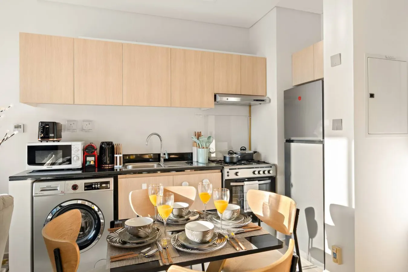 A bright kitchen and dining area with a table set beside the cooking counter.