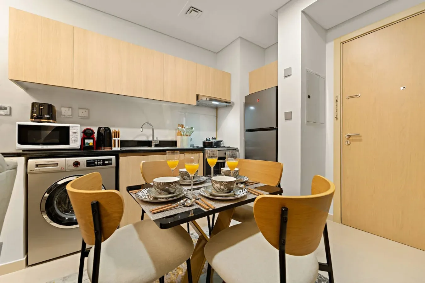 A compact kitchen and dining area with a table set beside the kitchenette.