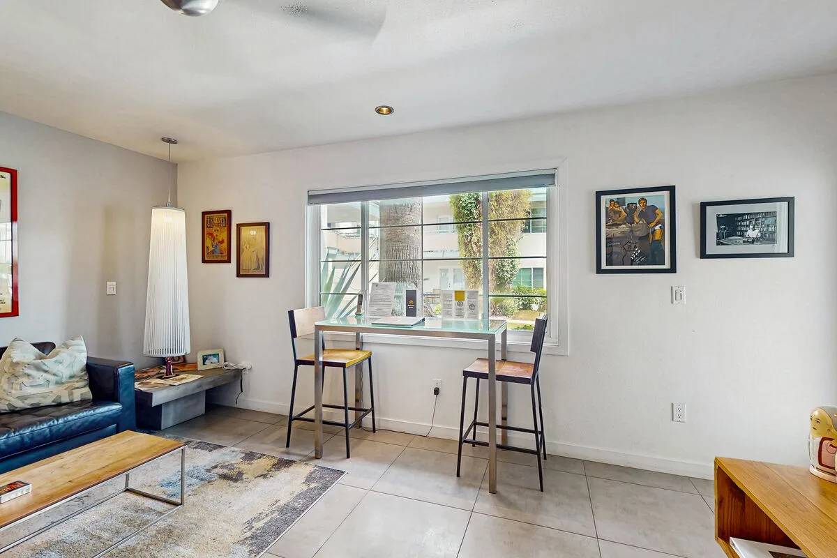 A bright living area with a blue sofa and a small table by the window.