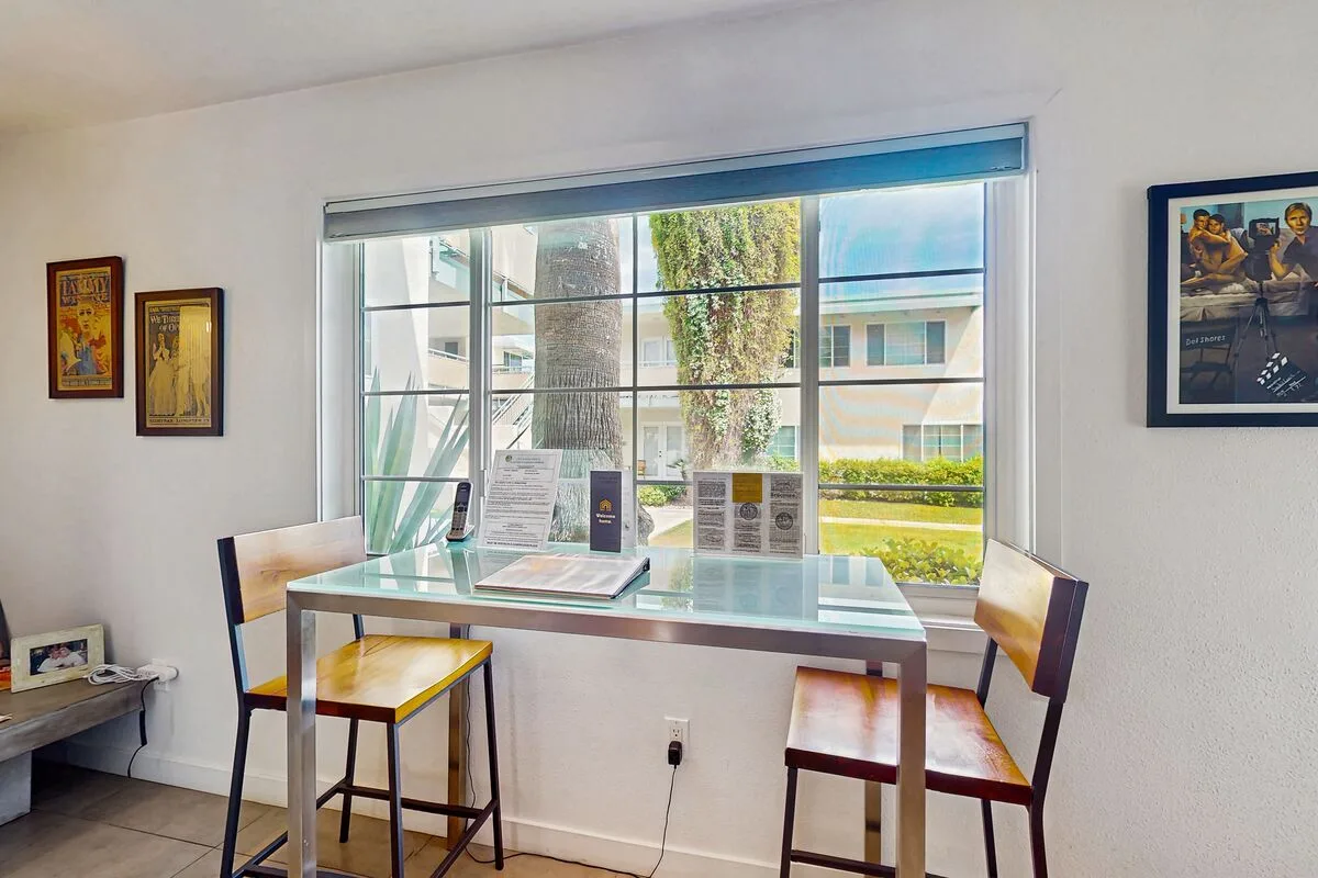 A bright dining area with a table and chairs beside a large window.