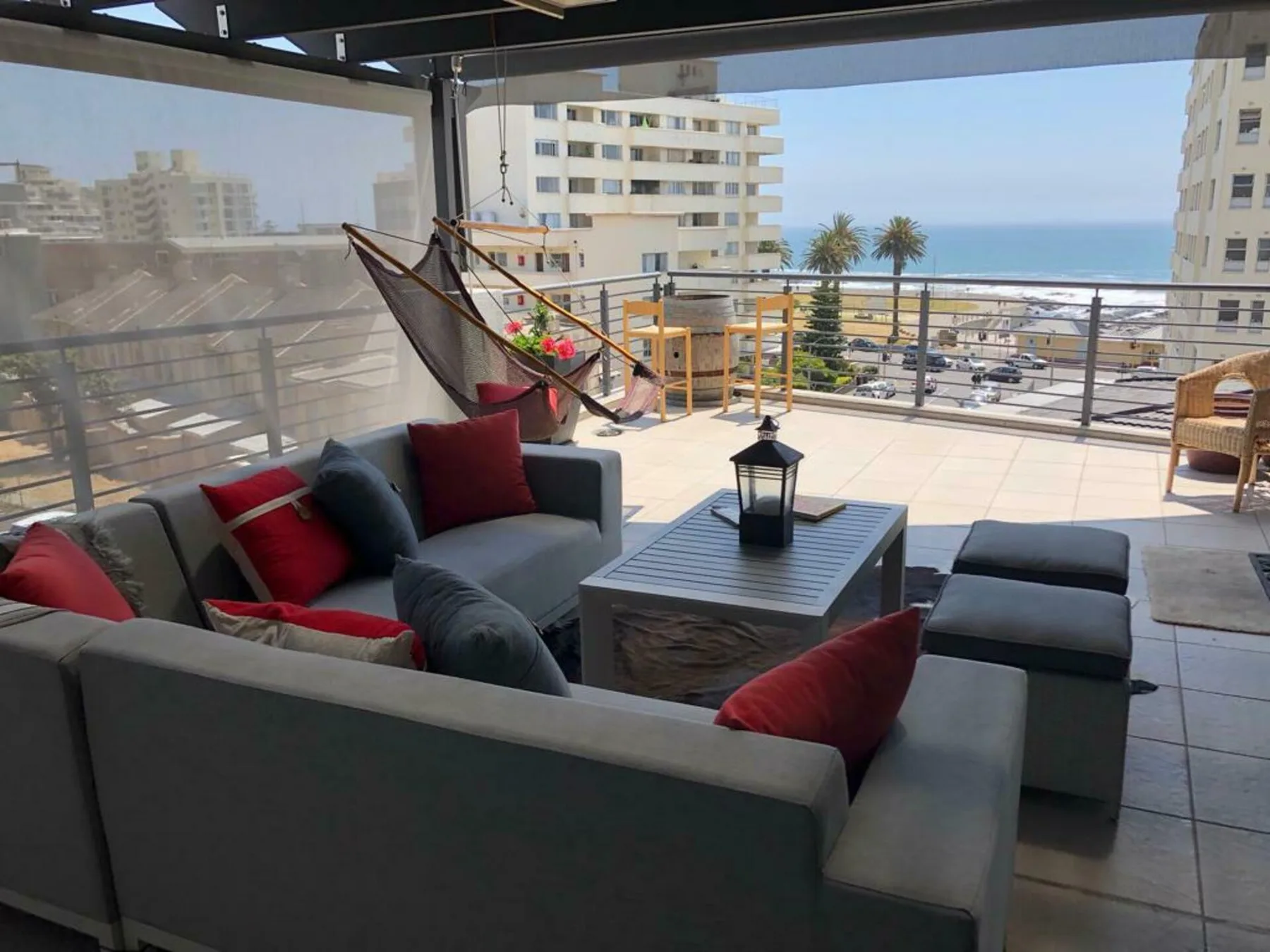 A covered terrace seating area overlooks nearby buildings and the sea.