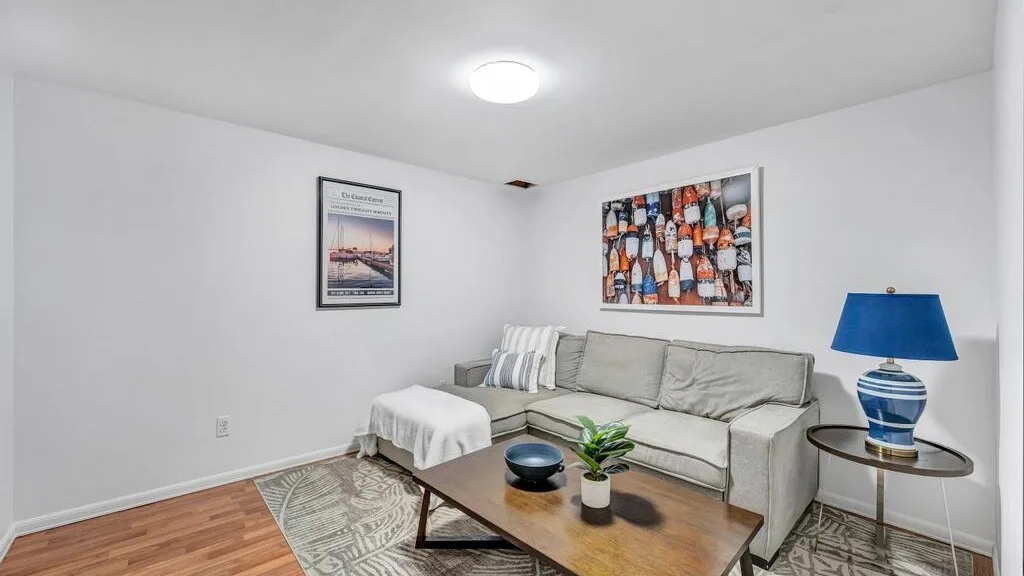 A living room with a sectional seating area, coffee table, and framed wall art.