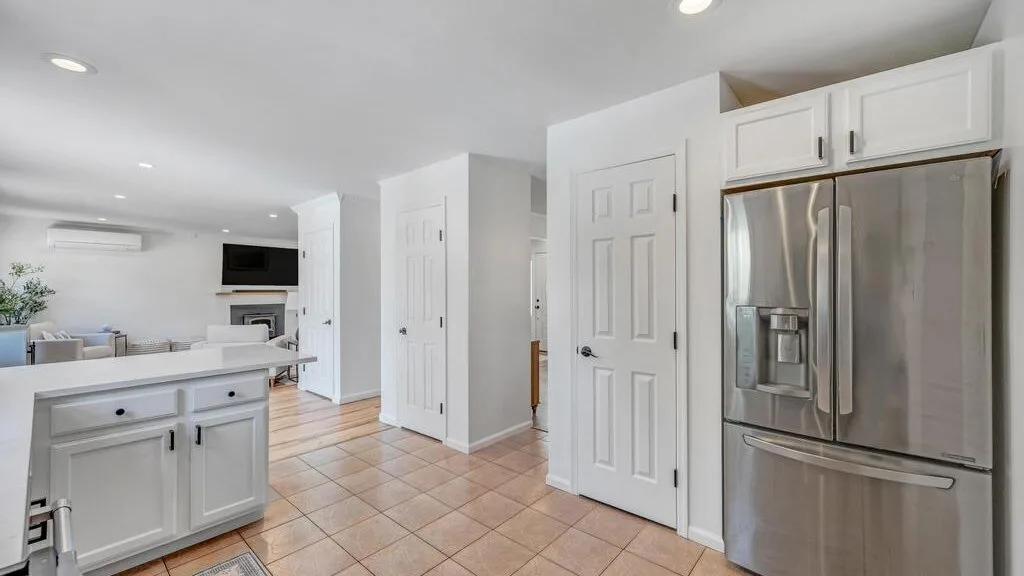 A bright kitchen with white cabinetry and stainless-steel appliances.