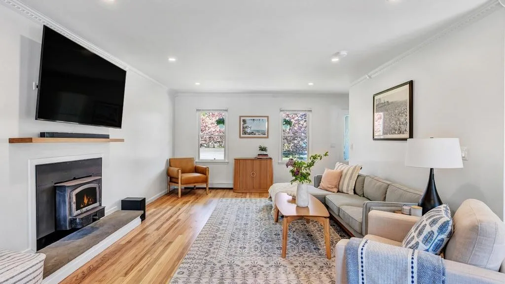 Living room with seating, a television, and a fireplace.