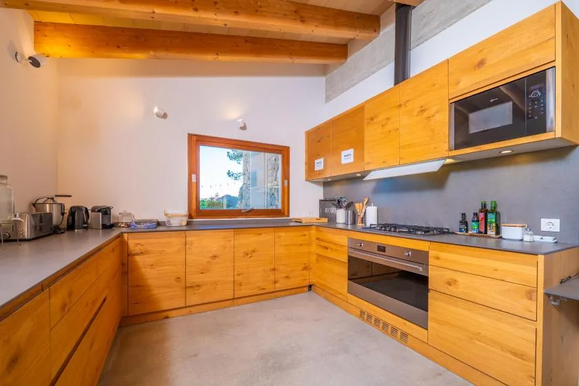 Una cocina luminosa con gabinetes de madera, encimera y electrodomésticos integrados.