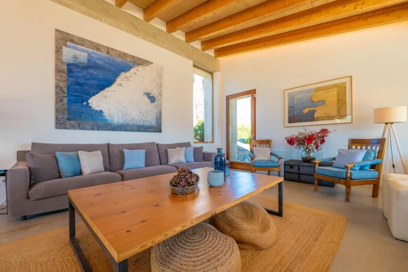 Una luminosa sala de estar con asientos alrededor de una mesa de centro de madera.