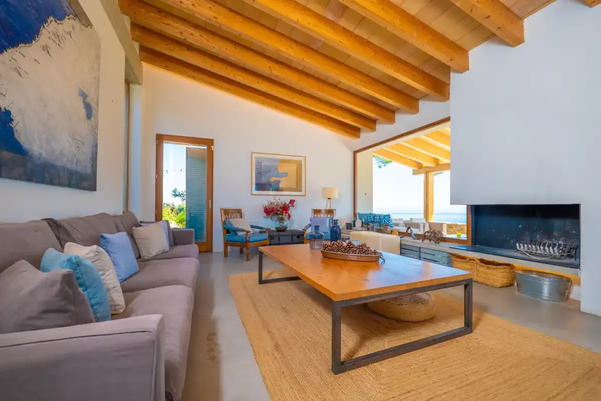 Una sala de estar luminosa con asientos, una mesa de centro y una chimenea.