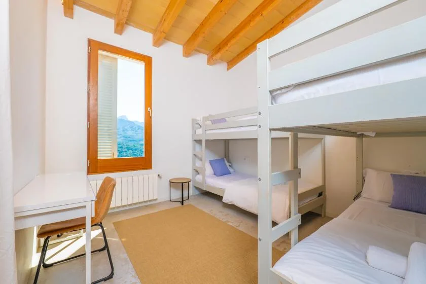 Un dormitorio con literas, un escritorio y una ventana con vistas al paisaje.