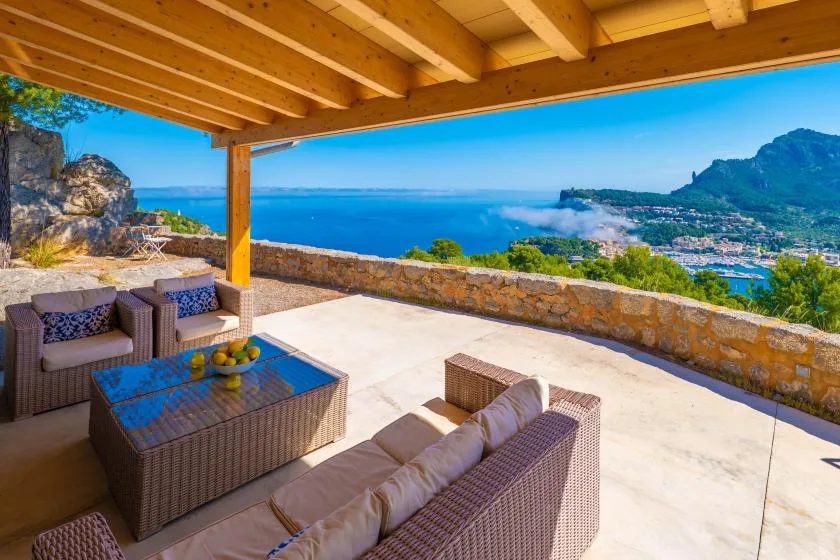 Una terraza cubierta con asientos al aire libre tiene vistas al mar y la costa.