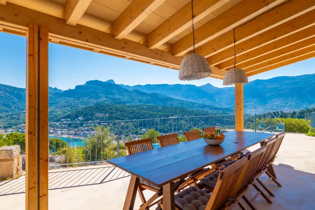 Una zona de comedor al aire libre tiene vistas a un valle montañoso.