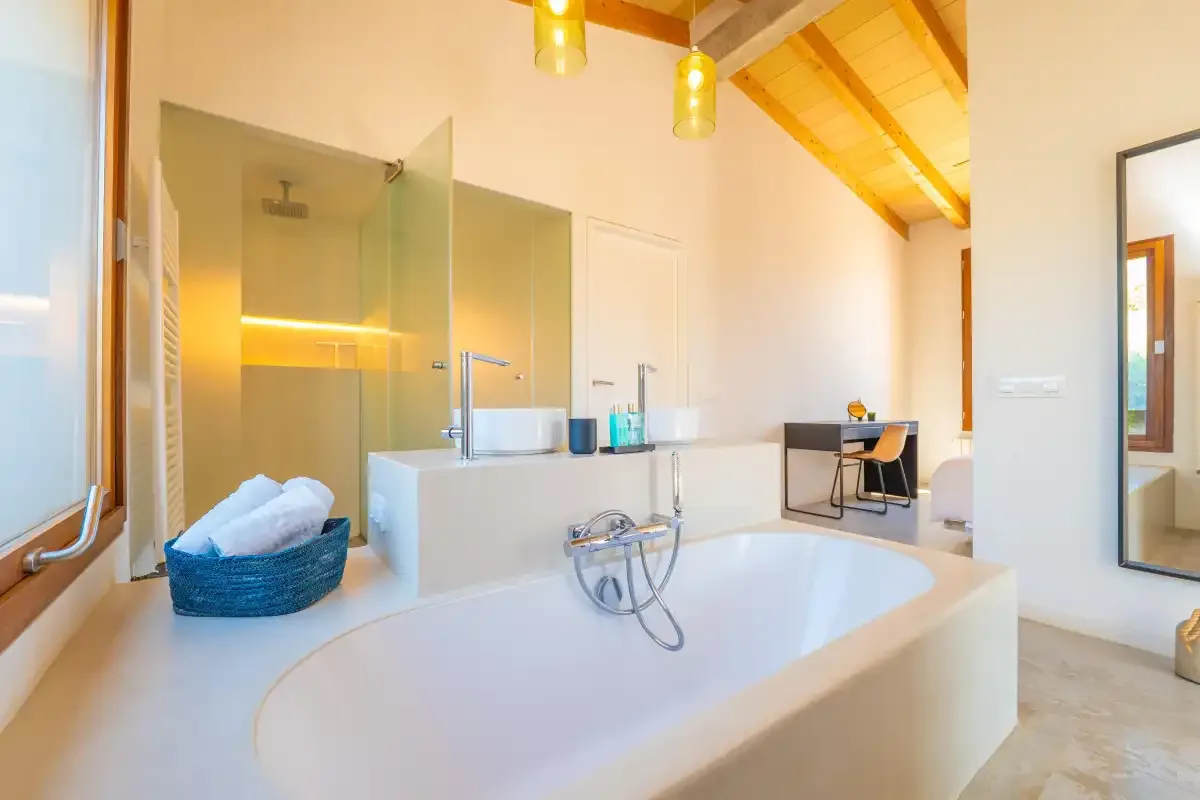 Un baño luminoso cuenta con una bañera amplia y una ducha de vidrio.