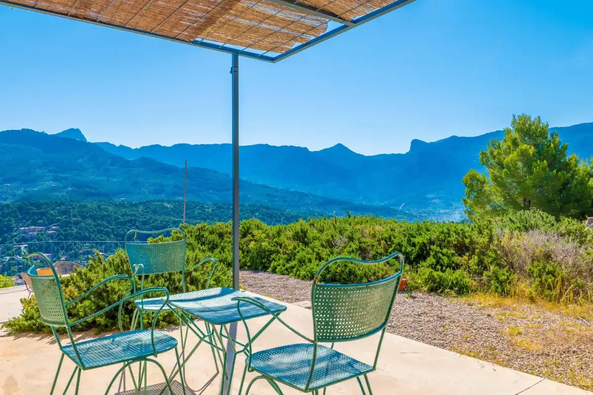 Una zona de estar al aire libre con sombra ofrece vistas a una cordillera.