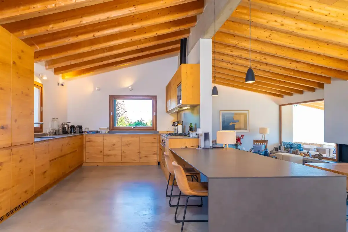 Una cocina y comedor con gabinetes de madera y una encimera larga.