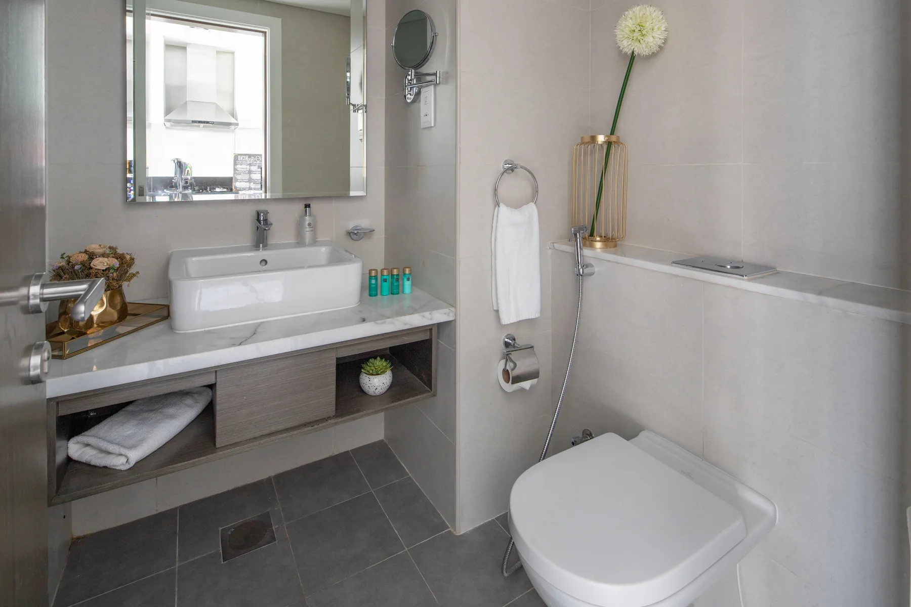 A modern bathroom with a sink, mirror, and toilet.