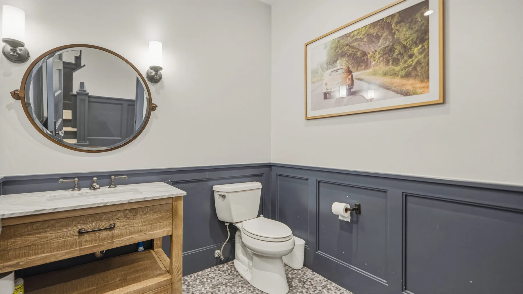A bathroom with a vanity, mirror, and toilet.