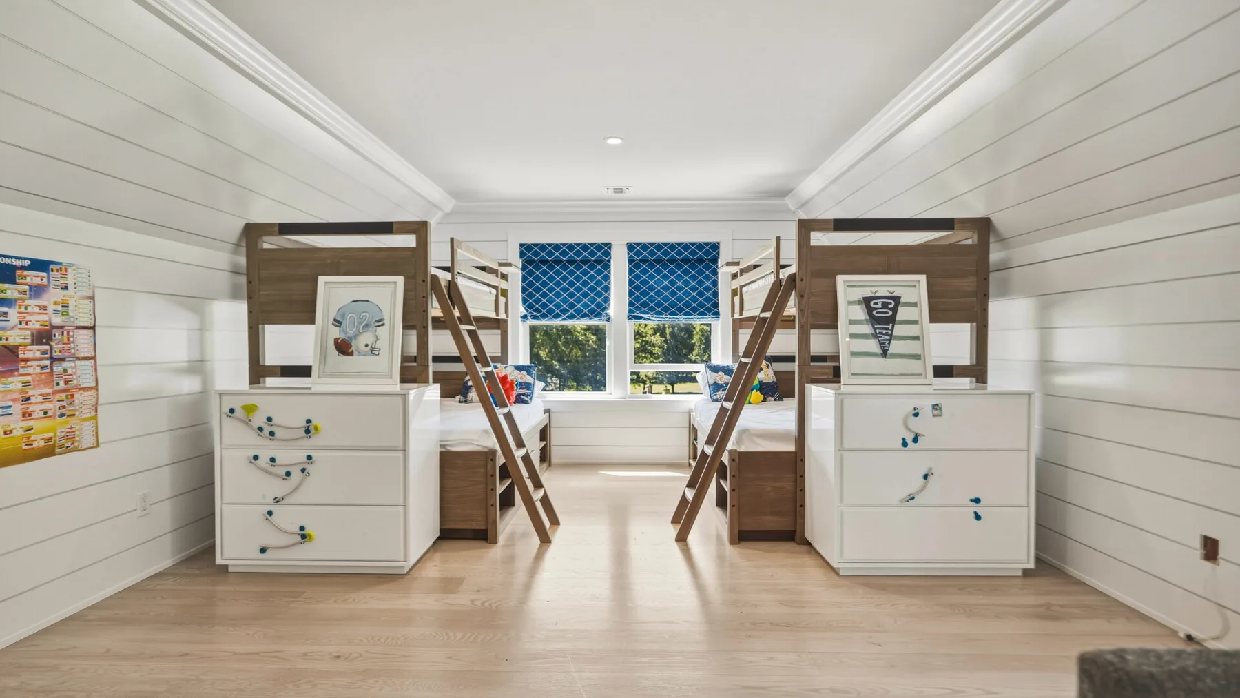 A bright bedroom with two bunk beds and a wide window.