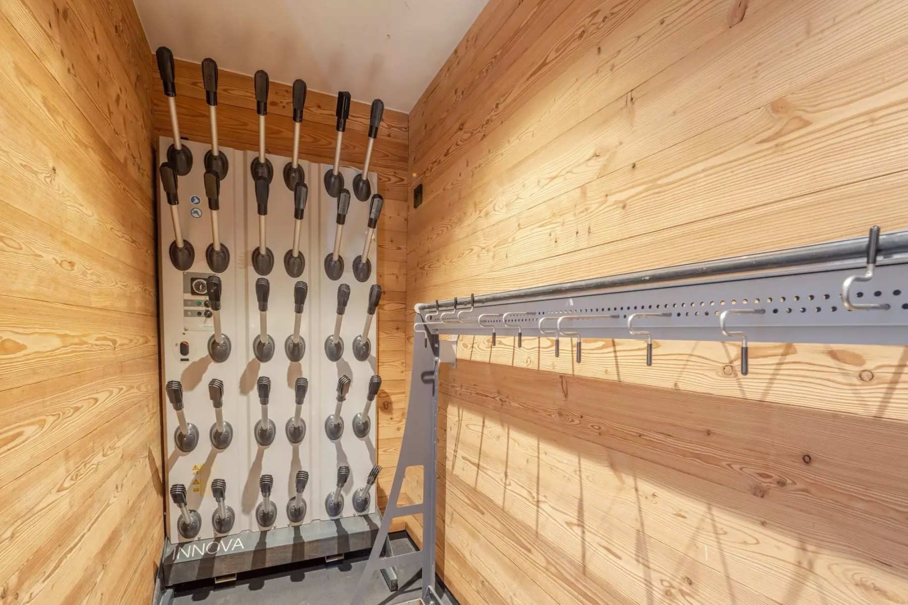 A wood-paneled room with a metal rack and rows of hanging equipment.