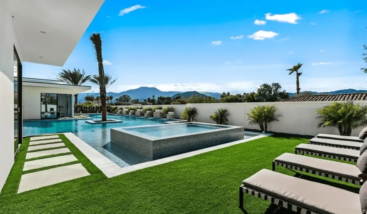 An outdoor pool area with a raised square feature and lounge seating.
