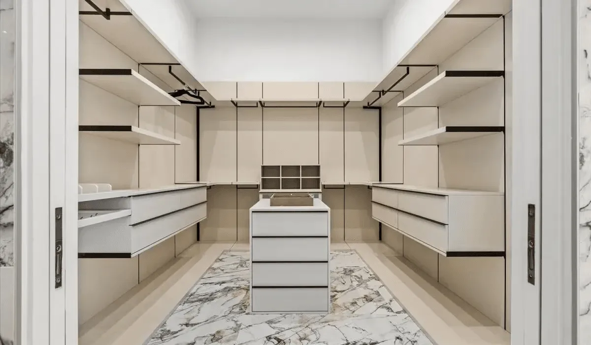 A walk-in closet with built-in shelving and a central island.