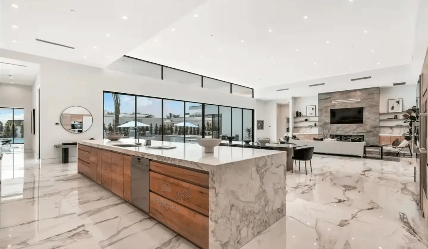 Open-plan kitchen and living area with a large island and floor-to-ceiling windows.