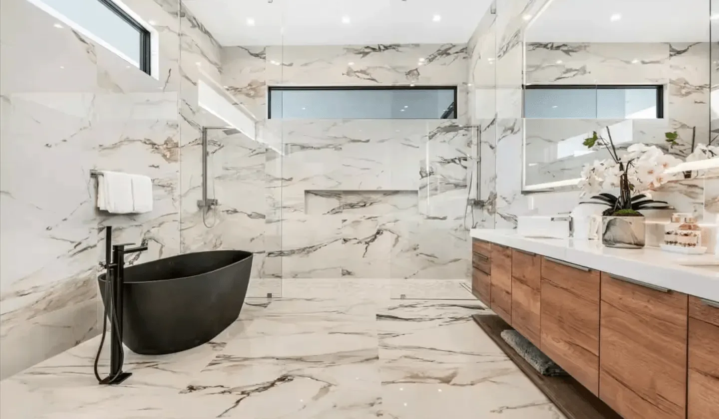 A bright bathroom with a freestanding tub and a long vanity.