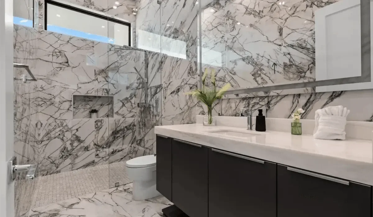 A modern bathroom with a long vanity, wall mirror, and glass shower.