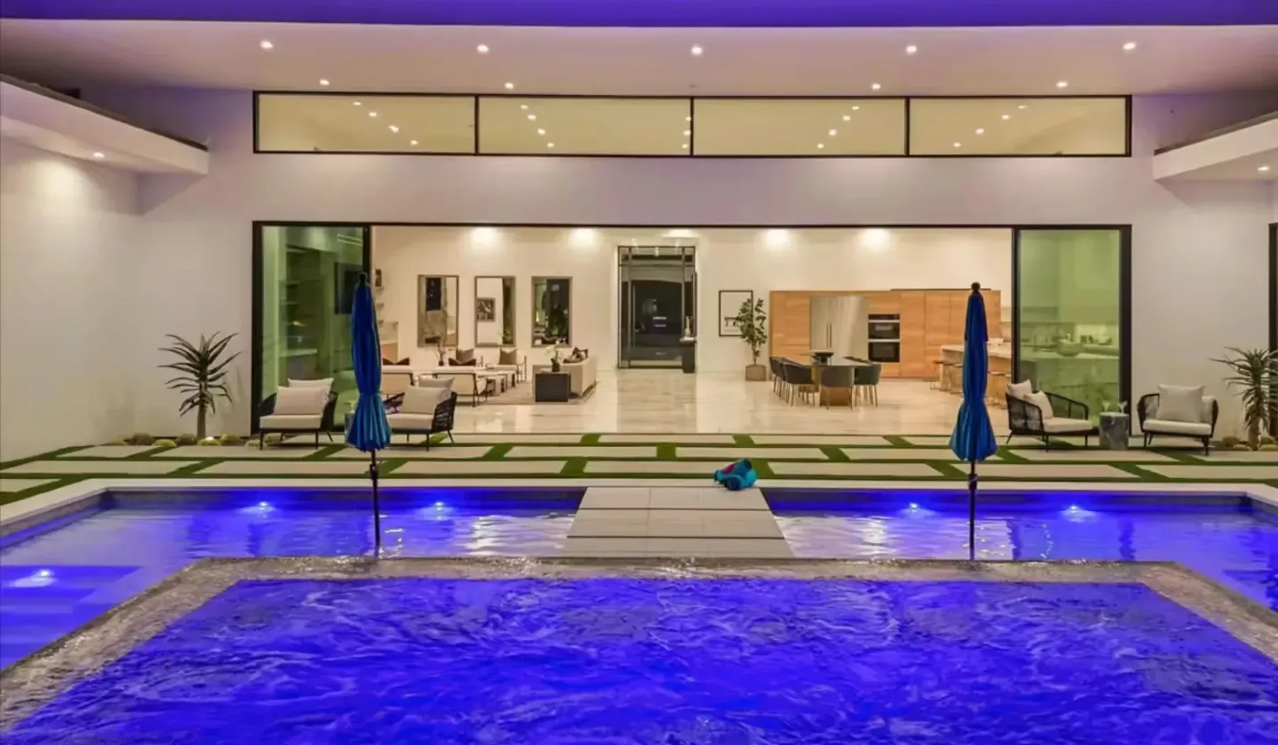 An indoor pool sits in front of a bright lounge area.