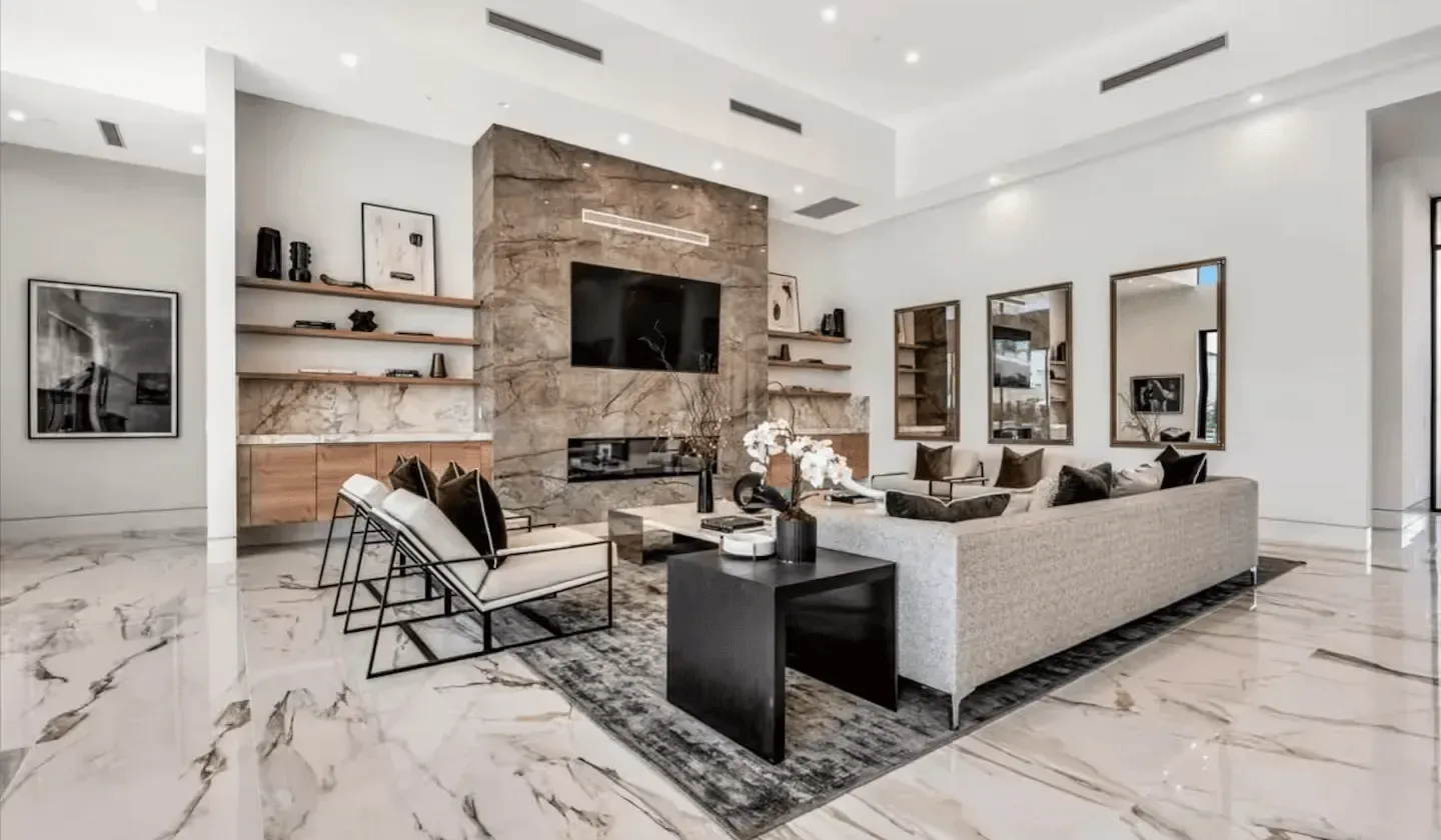 A bright living room with seating arranged around a television and coffee table.