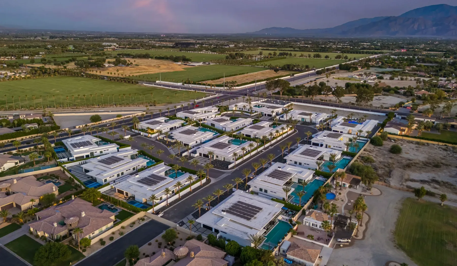 An aerial view of a residential neighborhood with homes and surrounding farmland.