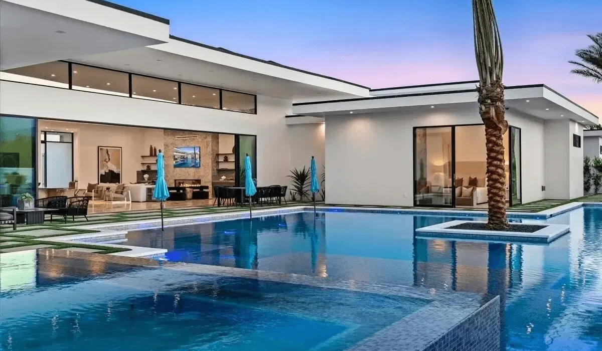 Modern house with a swimming pool and outdoor seating at dusk.