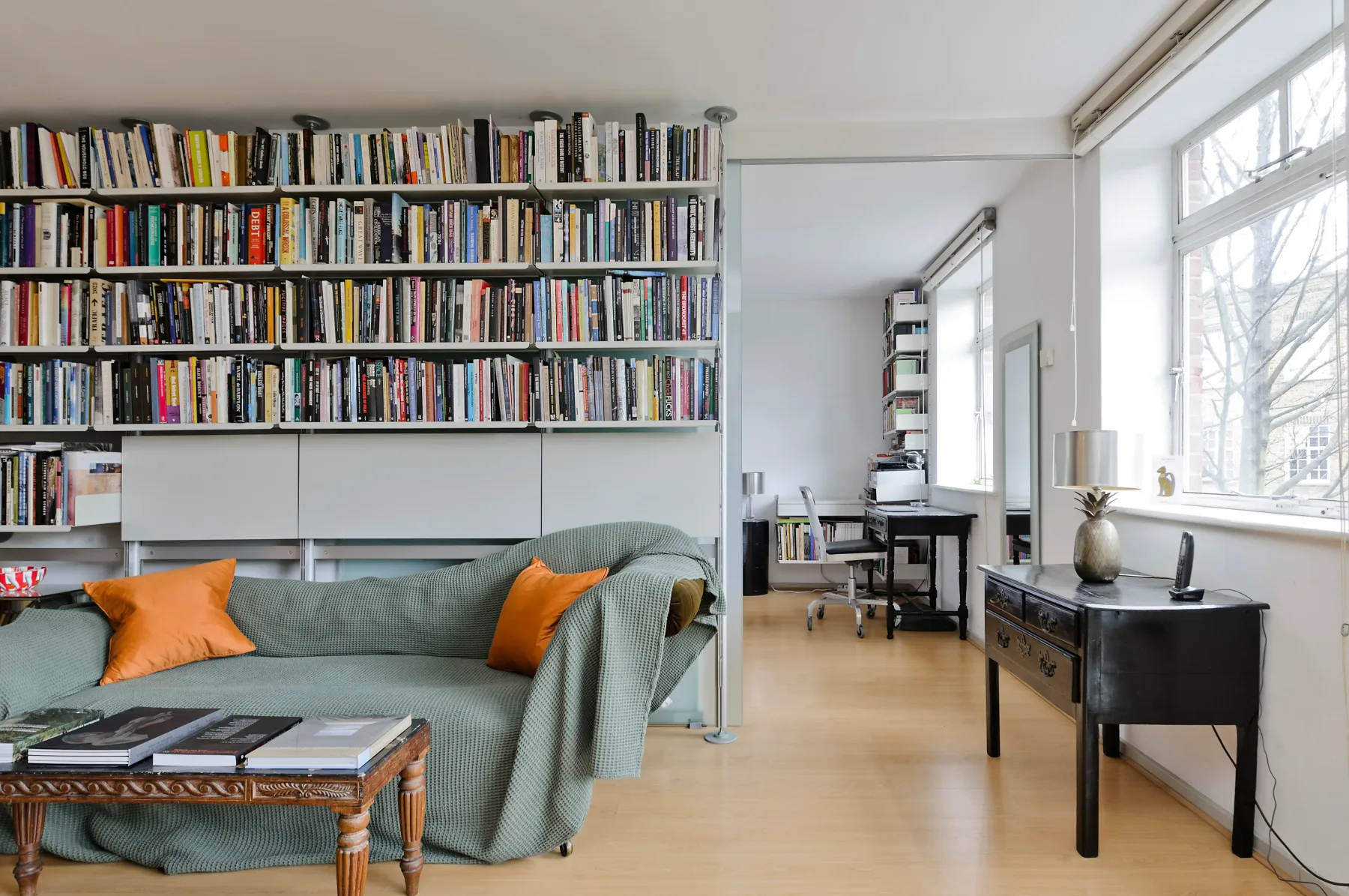 Una sala con estanterías llenas de libros y una zona de estar.