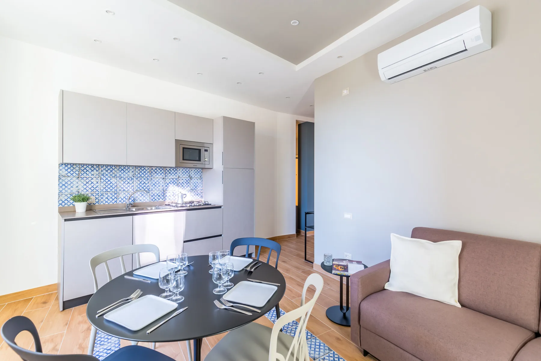 A bright living and dining area opens onto a compact kitchen, with a table and seating.