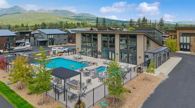 Un edificio moderno da a una piscina al aire libre y una zona de asientos.