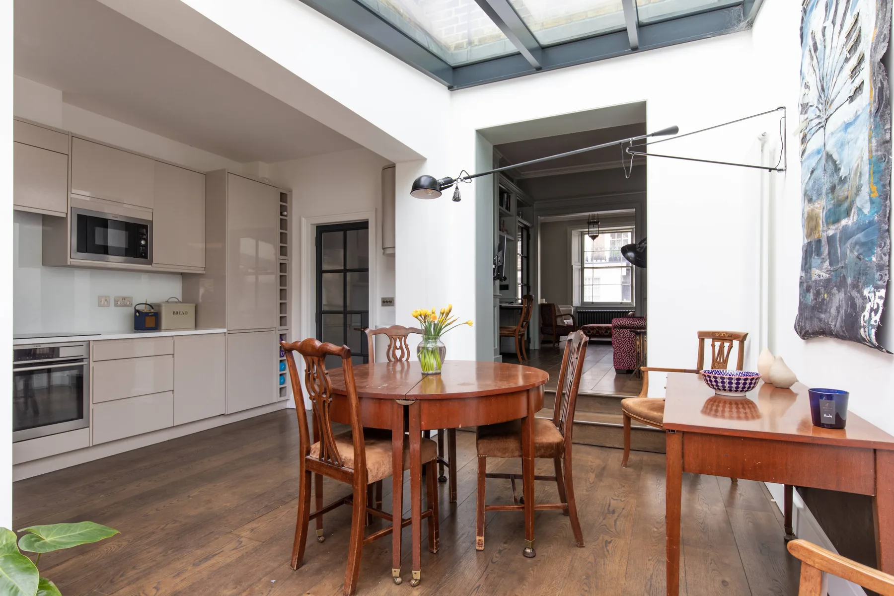 Comedor con mesa y sillas de madera junto a una cocina.