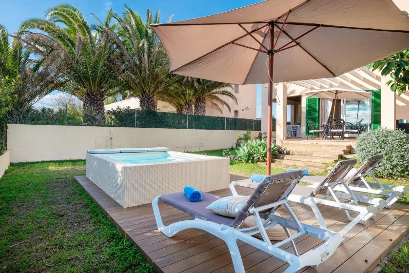 A sunny outdoor patio features a small pool, lounge seating, and a large umbrella.