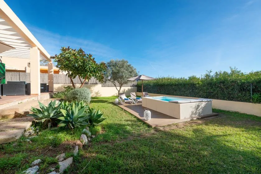 Outdoor patio with a small pool beside a landscaped garden.