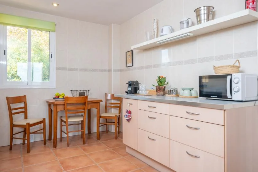A bright kitchen with a dining table and countertop appliances.