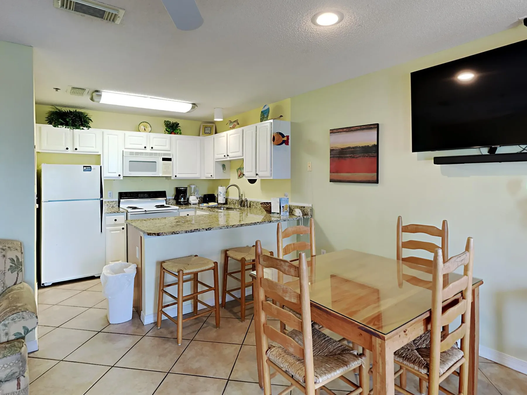 A kitchen and dining area with a table, chairs, and white cabinets.