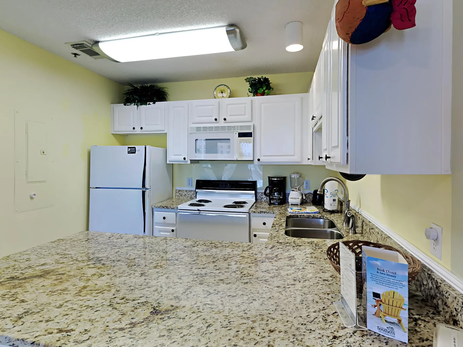 A kitchen with white cabinets, a refrigerator, and a countertop.