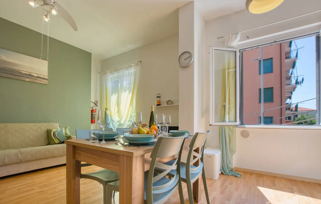 Comedor con una mesa de madera junto a una ventana grande abierta.
