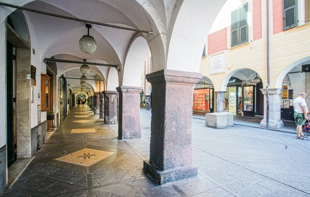 Un pasaje cubierto con suelo de piedra y tiendas a lo largo del paseo abierto.