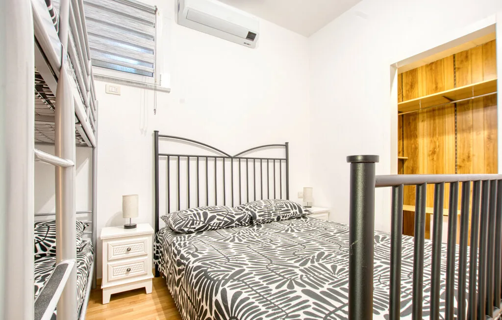 Un dormitorio con una cama estampada y un armario de madera.