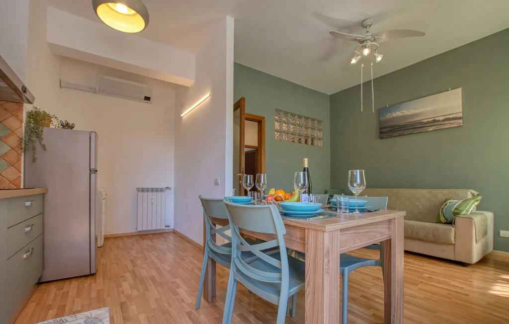 Un comedor con la mesa puesta junto a una pequeña zona de estar.