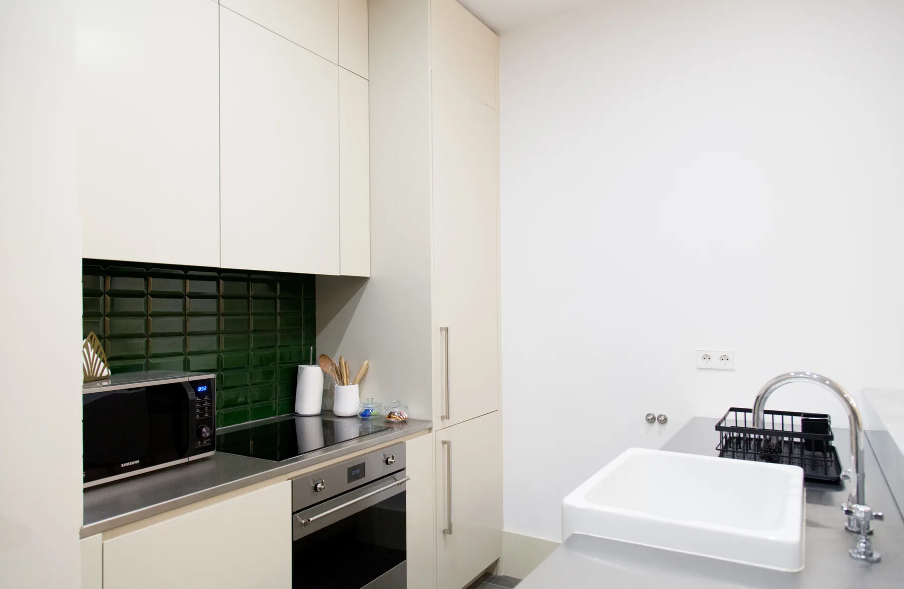 Una cocina compacta con microondas junto a un fregadero.