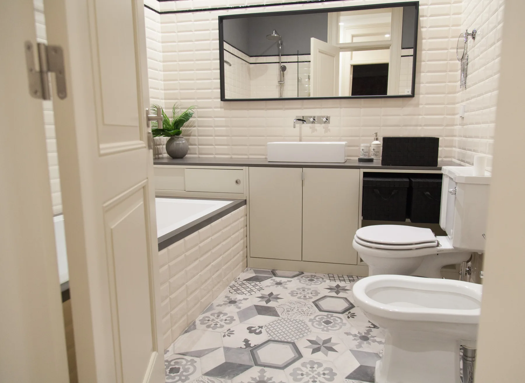Un baño alicatado con bañera, lavabo e inodoro.