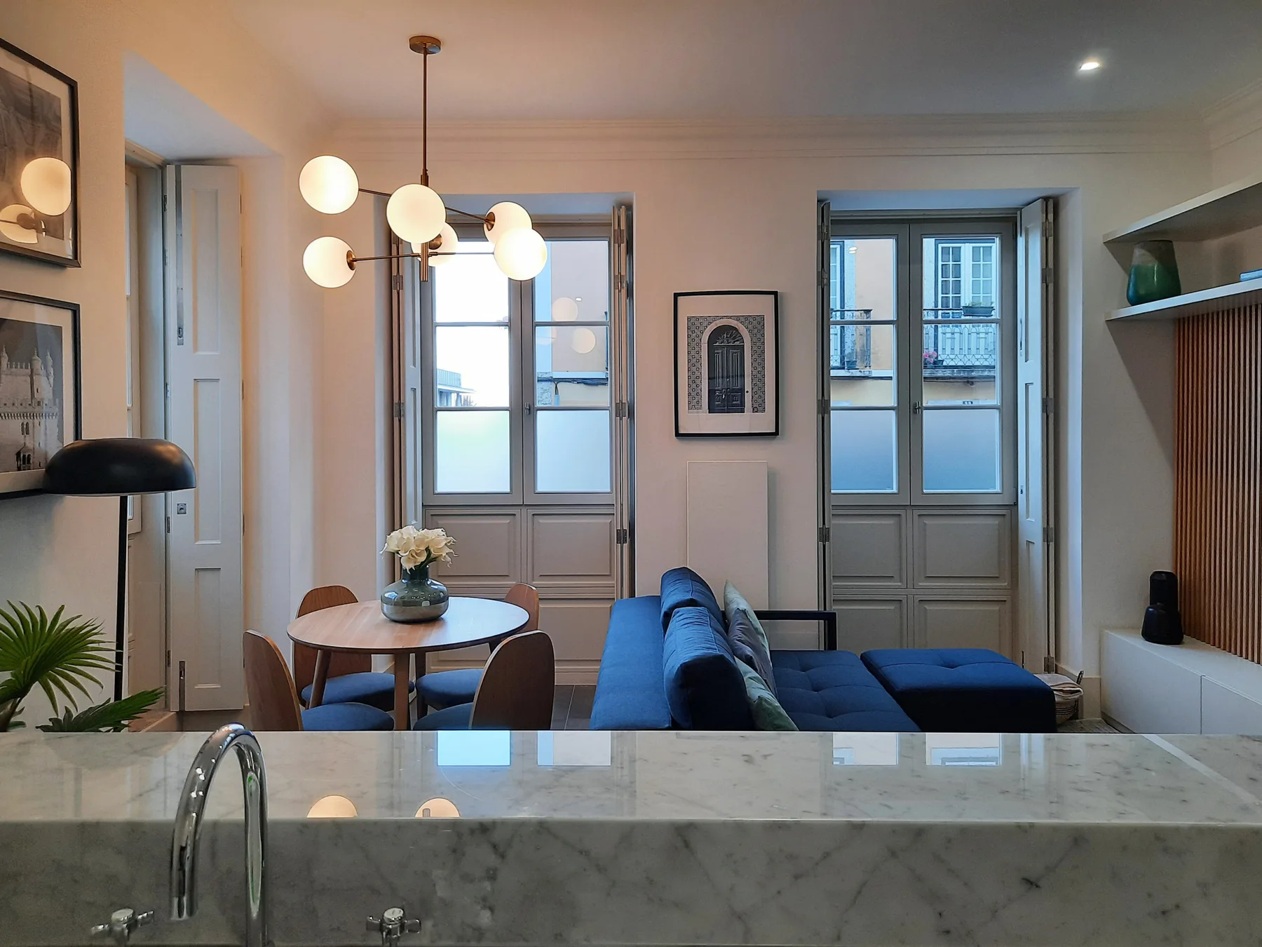 Sala de estar con mesa de comedor y asientos azules junto a la encimera de cocina.